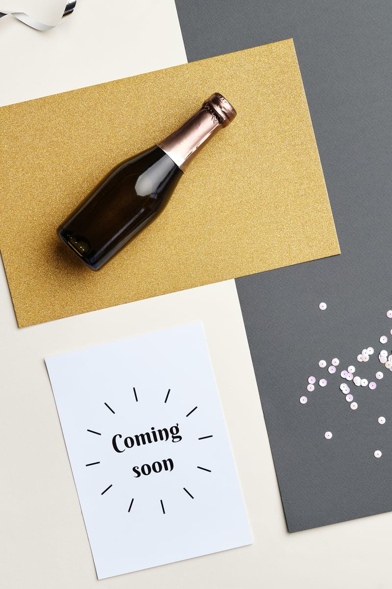 Flat lay image of a champagne bottle and festive decorations, perfect for celebratory themes.
