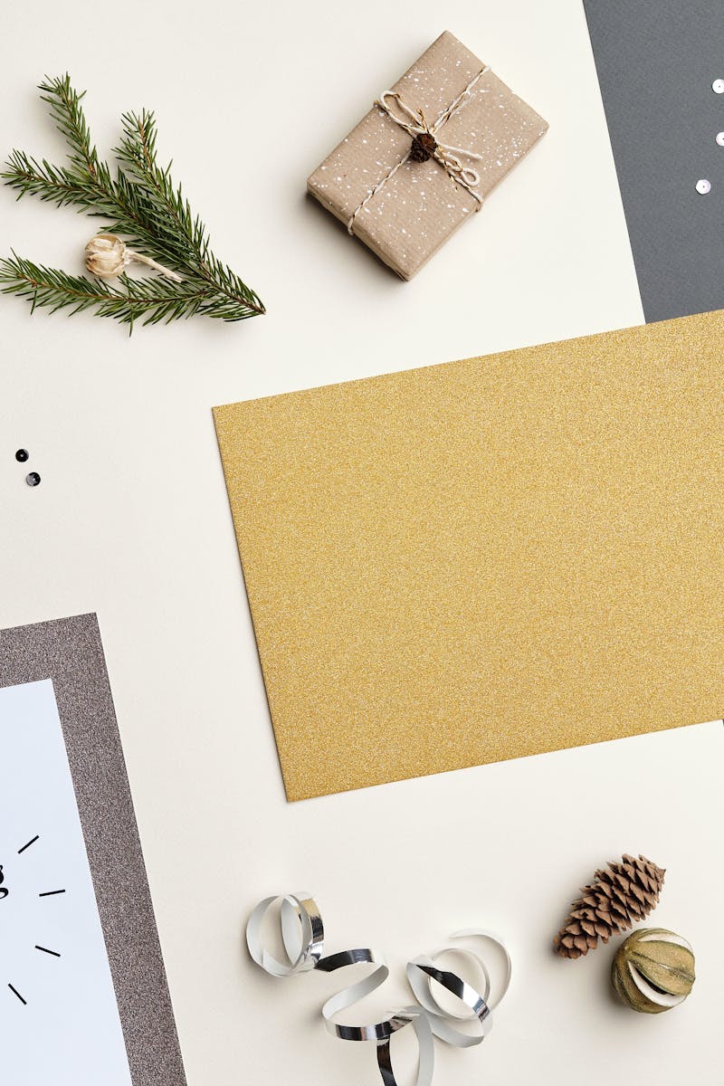 Elegant holiday flat lay featuring a gift, dried oranges, and festive decor.